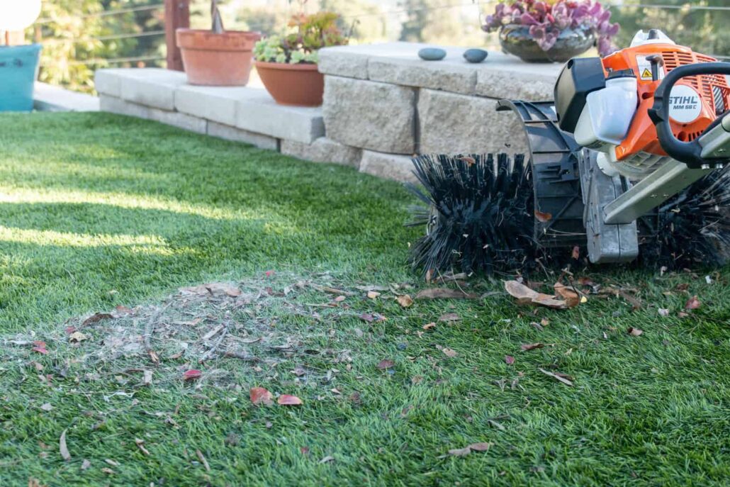 Turf cleaning machine lifting debris from synthetic grass, demonstrating TurFresh’s eco-friendly and pet-safe formula that eliminates odors and revitalizes artificial lawns for a cleaner, fresher outdoor space.