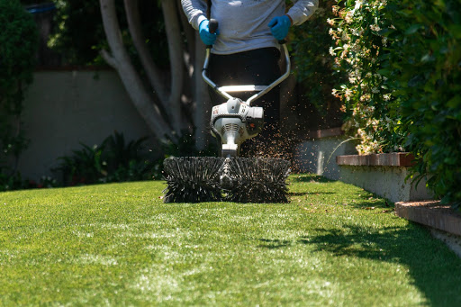 "A technician using a professional turf cleaning machine to deep-clean artificial grass, showcasing TurFresh’s powerful, eco-friendly formula that removes pet odors and is safe for families and pets."