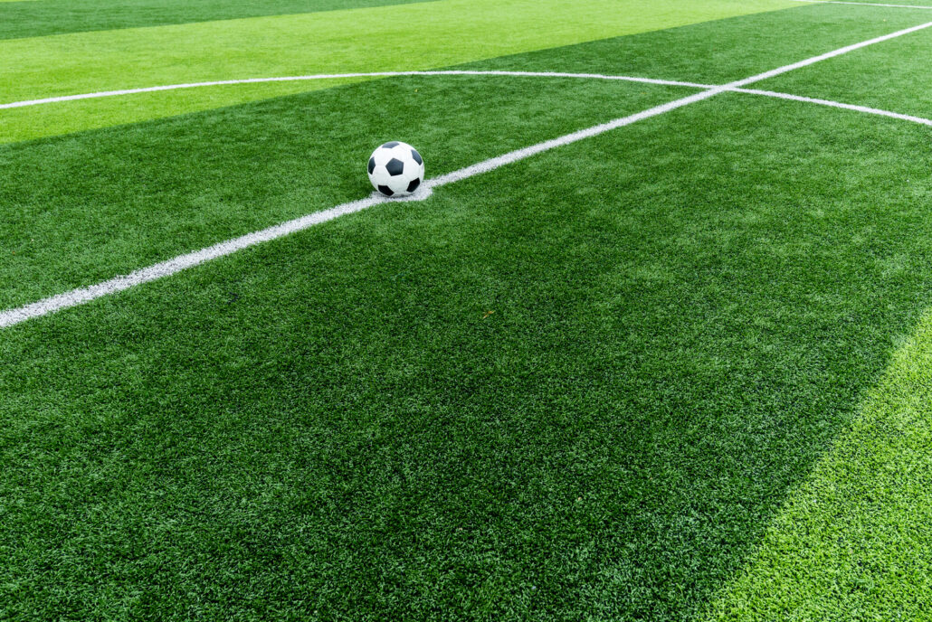 Clean artificial soccer field with a ball at center, maintained using TurFresh’s professional-grade, non-toxic turf cleaner that eliminates odors and is safe for athletes, pets, and the environment.