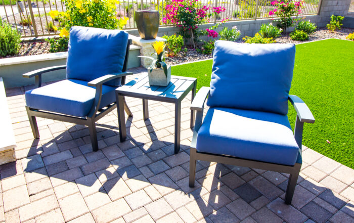 Outdoor patio chairs beside vibrant artificial turf maintained with TurFresh products