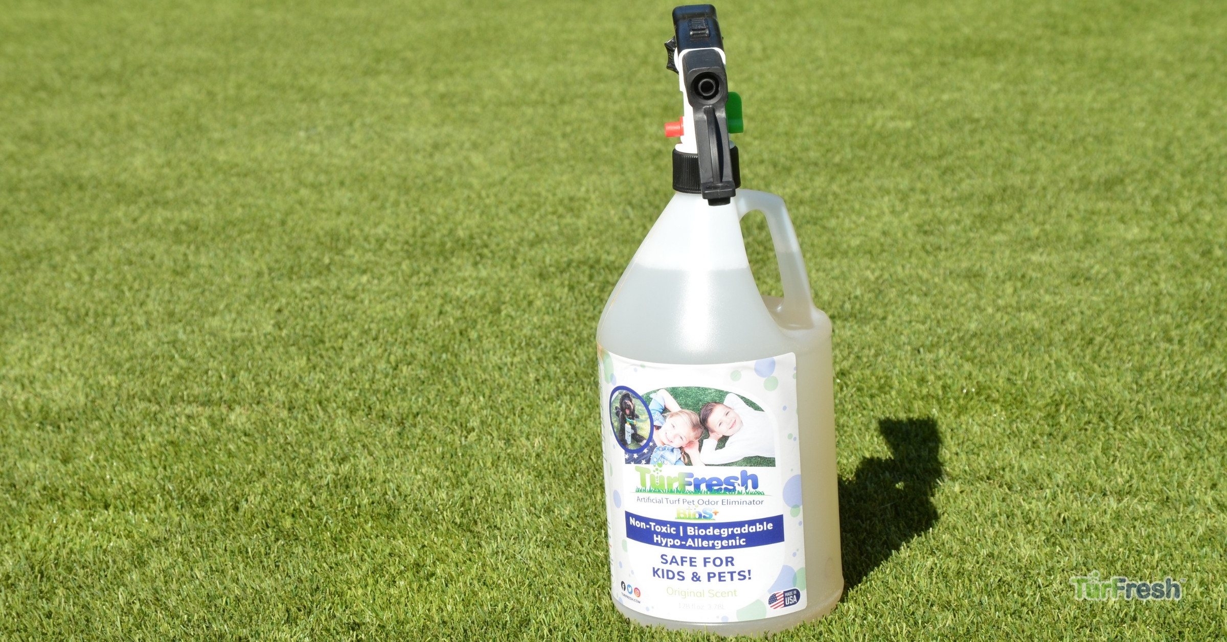 Artificial turf maintenance service brushing leaves from lawn Technician brushing synthetic turf lawn to remove leaves and debris