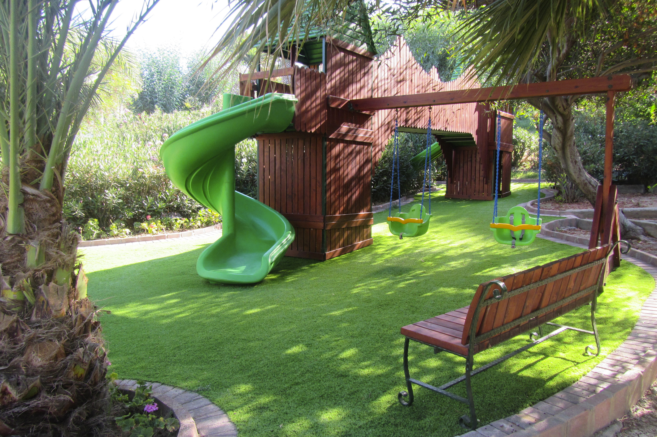 Children’s playground with artificial turf surface for safe and clean play — maintained by TurFresh.