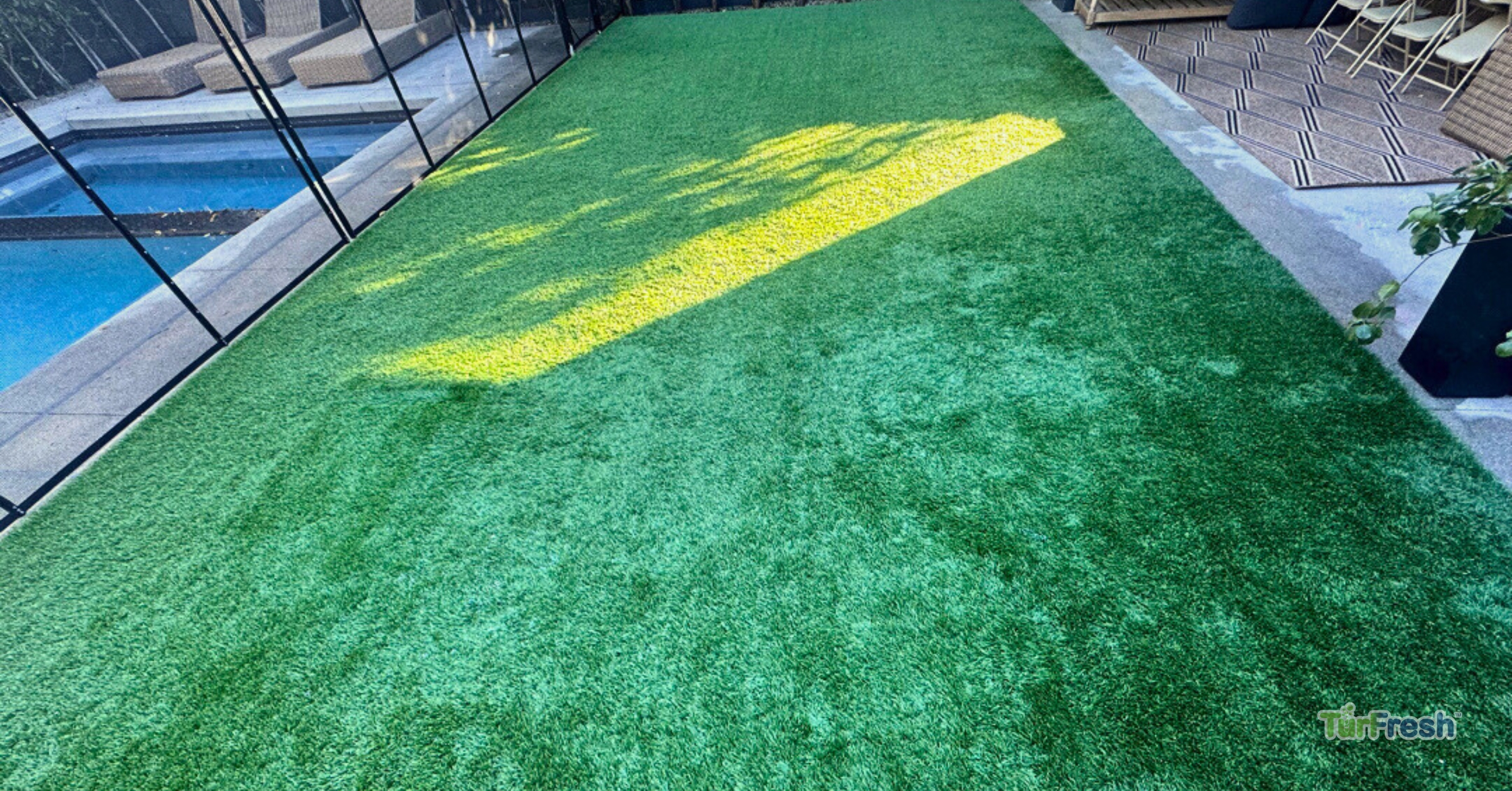 Artificial turf maintenance service brushing leaves from lawn Technician brushing synthetic turf lawn to remove leaves and debris