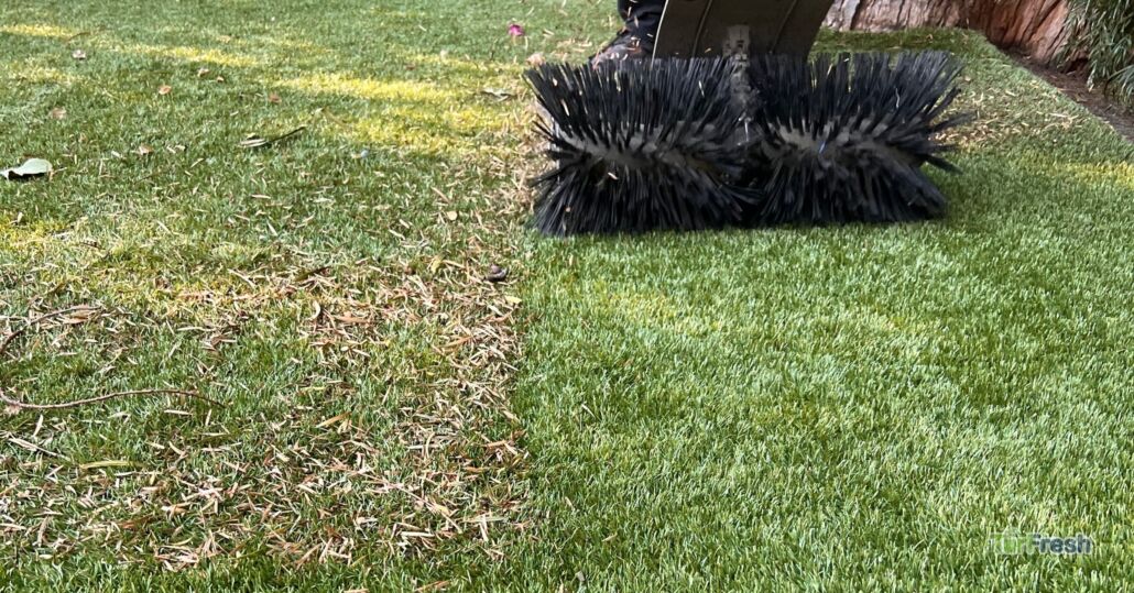 Technician performing TurfBloom services on flattened artificial grass in Las Vegas.