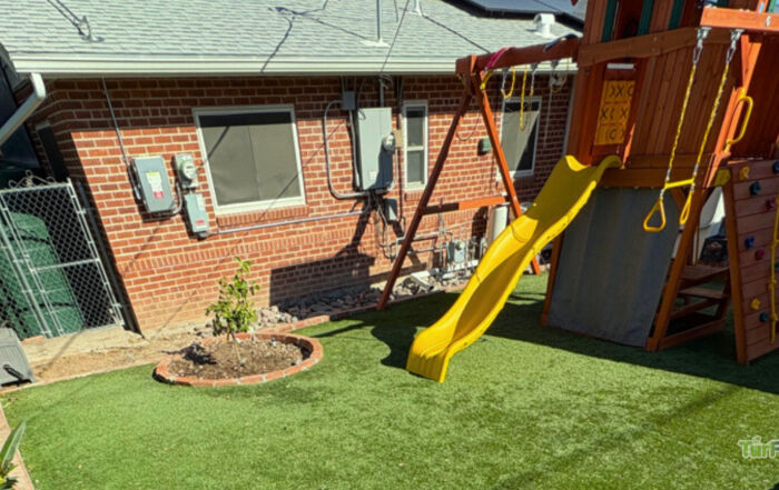 Artificial turf playground area in a backyard, maintained by TurFresh for a clean and safe surface for kids.