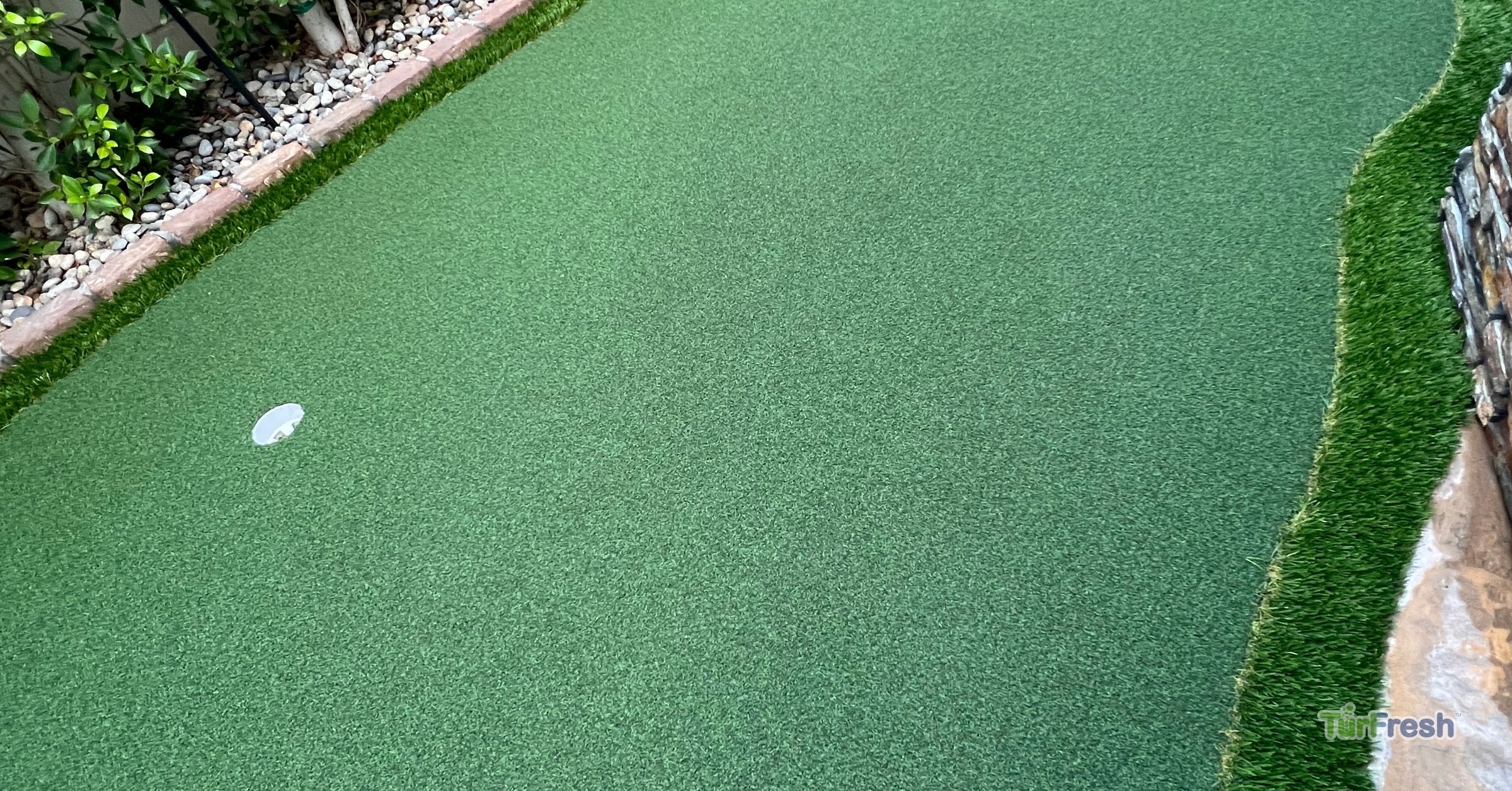TurFresh delivers professional care for backyard putting greens with artificial turf maintenance Clean and well-maintained backyard putting green with artificial turf, serviced by TurFresh.