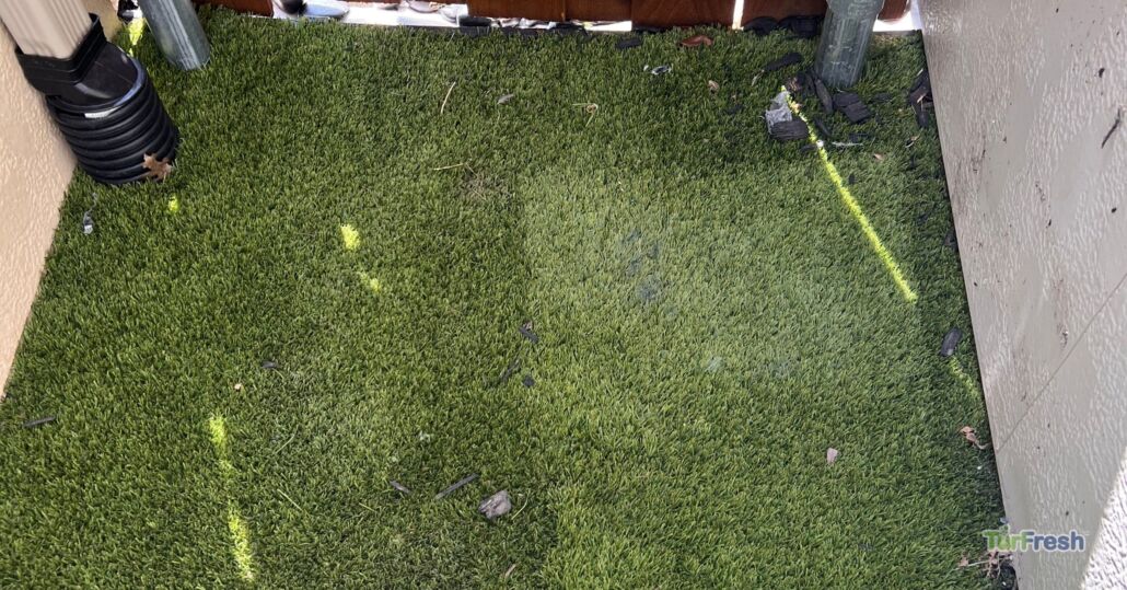 Artificial turf in a tight corner area with debris buildup – TurFresh cleaning and maintenance zone.