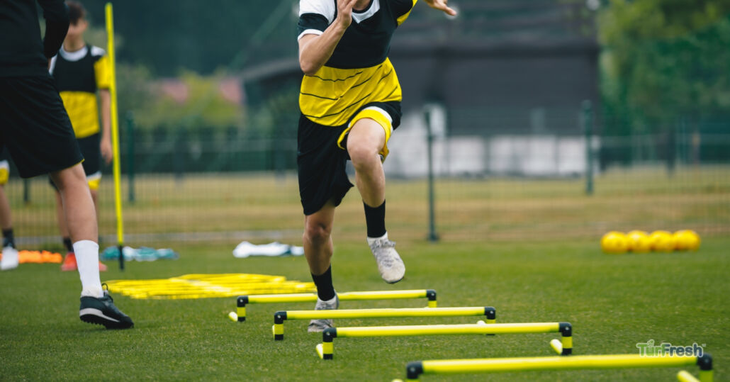 Athletes performing agility drills on artificial turf field maintained by TurFresh.
